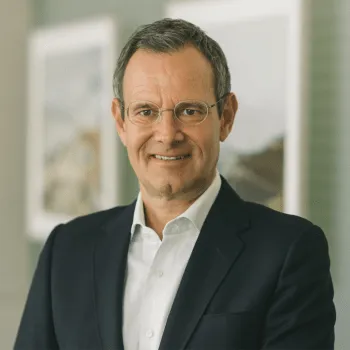 Porträt von Manfred Pletzer, CEO der Pletzer Gruppe, im Anzug mit freundlichem Blick in modernem Büroambiente.
